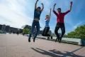 Porträtfotografie Arbeitsproben 11 Drei Studierende auf der Unibrück springen gleichzeitig hoch