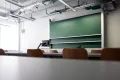 Photo: Seminar room, photographed from the table with a view to the front of the boards and a monitor.