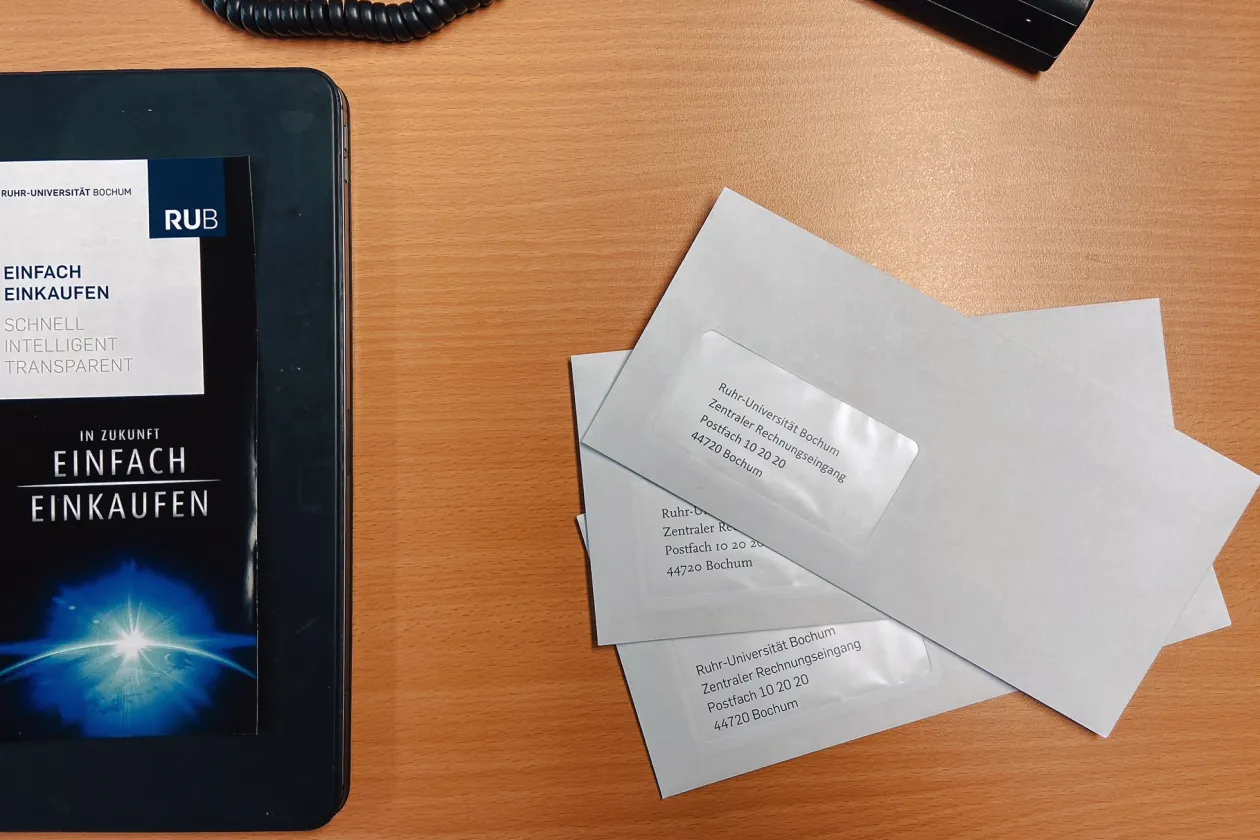 Auf einem von oben fotografierten Schreibtisch liegen drei an die RUB adressierte Briefe und ein Faltblatt zum Projekt Einfach einkaufen.