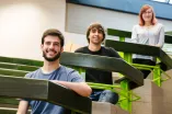 Porträtfotografie Arbeitsprobe 12 Drei Studierende sitzen im Hörsaal und lächeln dem Betrachter zu