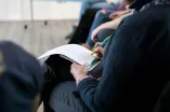 Teilnehmender mit Mitschrift beim Workshop