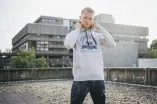 Mann vor Bibliothek mit grauem Hoodie