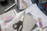 Collagematerial wie zum Beispiel Schere, Stift, Papier und vieles mehr liegen auf einem Tisch
