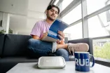 Student mit Unishop-Merchandise