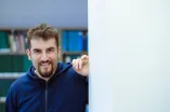 Burak Yilmaz lächelt in die Kamera und lehnt mit dem linken Arm an einer Wand 
