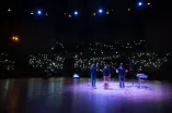 Photo: Band playing in the darkened Audimax, the audience holding up lights.