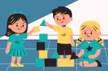 Drei Kita-Kinder, ein Junge und zwei Mädchen, spielen mit Bauklötzen.