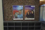 Foto: Poster (Werberahmen) an einer Backsteinwand in einem Campus-Gebäude