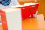Eine Person hält ein Buch mit dem Titel "Deutsche Gesetze" in der Hand