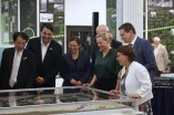 Fotodokumentation der Ausstellungseröffnung. An zentraler Stelle ist das Architekturmodell der Universität zu sehen, umgeben von den Rektor*innen der UA Ruhr, Kanzlerin, Leitung des Universitätsarchivs, OB der Stadt Bochum sowie weiteren Gästen