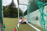 Zwei Mädchen lesen Bücher in einem Tor auf einem Sportplatz.