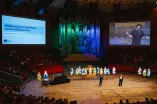 Welcome Ceremony for First-Year Students in the Audimax: View from the seating area toward the stage, side screens, and the illuminated organ