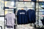 Das Foto zeigt mehrere aufgehängte Shirts und Sweatshirts im Unishop auf dem RUB-Campus