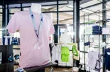 Das Foto zeigt den Unishop auf dem Campus, im Vordergrund einen T-Shirt-Mannequin mit einem RUB-Lanyard um den Hals