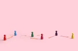 Spielfiguren mit Pfeilen verbunden auf rosa Hintergrund