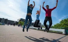 Porträtfotografie Arbeitsproben 11 Drei Studierende auf der Unibrück springen gleichzeitig hoch