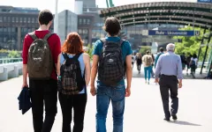 Junge Leute in der Rückansicht auf der Unibrücke auf dem Weg zum Campus der RUB.