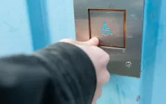 Das Bild zeigt die Taste für Rollstuhlfahrende in einem Aufzug auf dem Campus