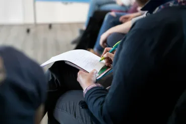 Teilnehmender mit Mitschrift beim Workshop