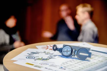 Kompass liegt auf einem Tisch mit Zetteln