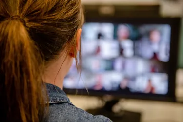 Rückansicht Frau vor Computerbildschirm