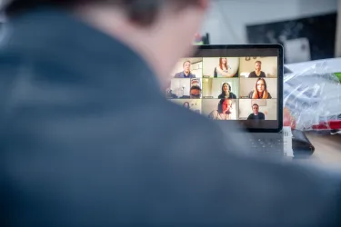 Person vor Rechner mit Videokonferenz