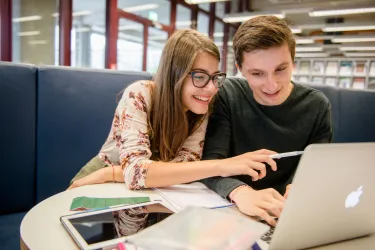 Zwei Studierende lernen gemeinsam am Laptop