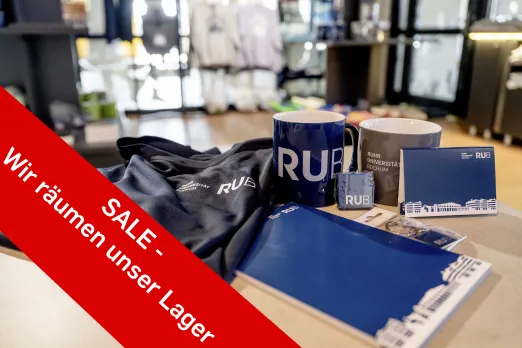 Das Foto zeigt verschiedene Artikel im Campusshop und hat einen Störer mit der Aufschrift "Sale - wir räumen unser Lager"