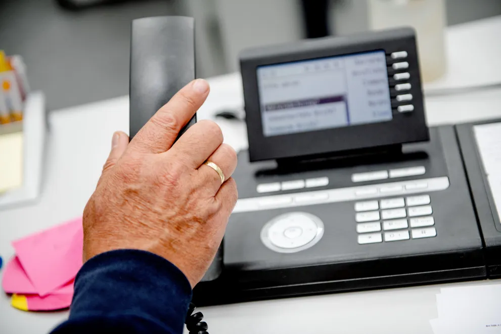 Hand mit Telefonhörer