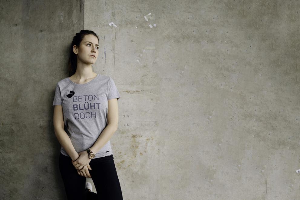 Frau mit T-Shirt vor grauer Wand