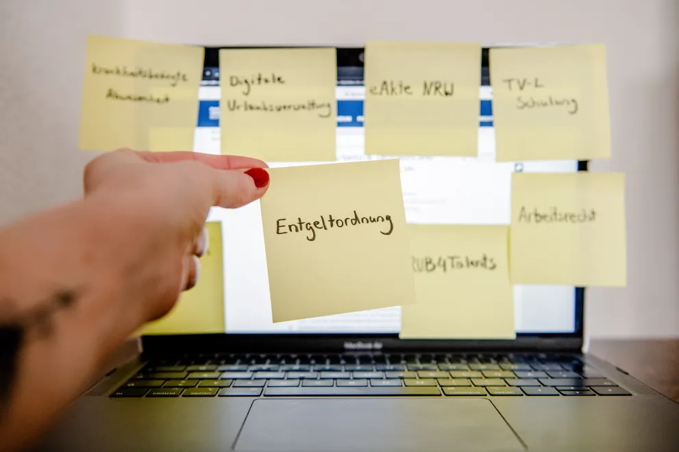 Post-It Entgeltordnung vor Laptop.