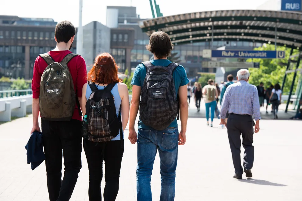 Junge Leute in der Rückansicht auf der Unibrücke auf dem Weg zum Campus der RUB.