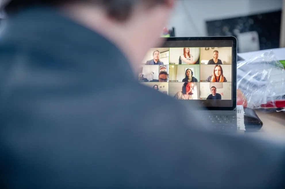 Person vor Rechner mit Videokonferenz