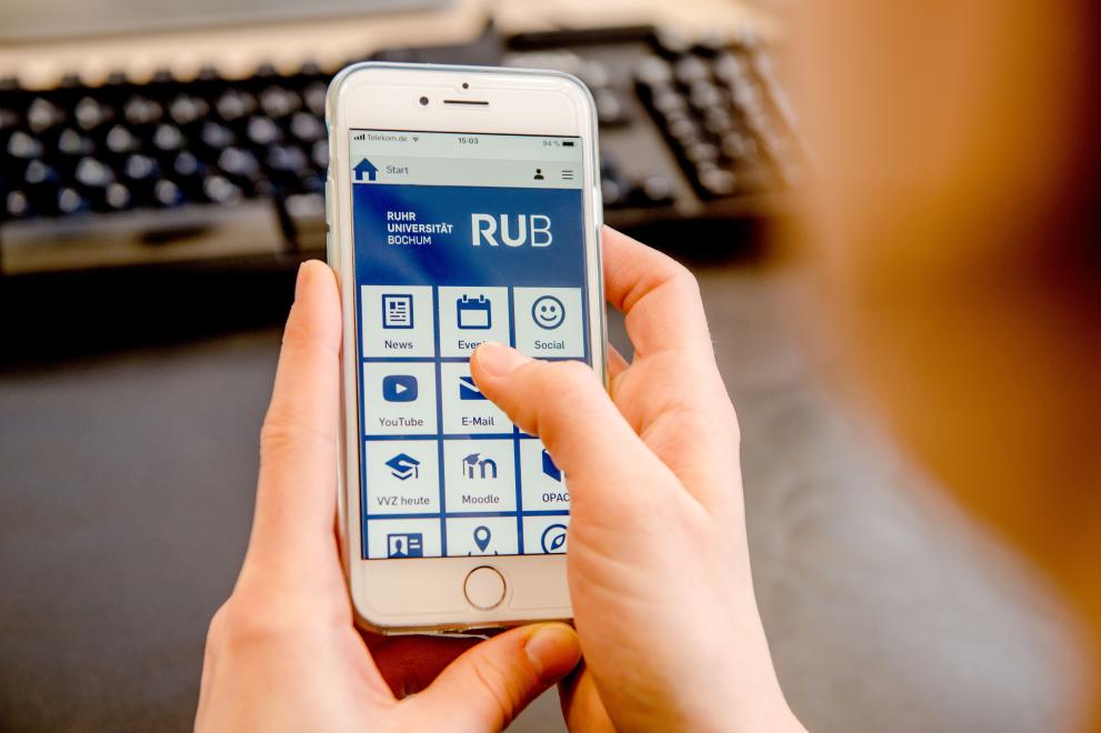Nutzerin bedient Handy mit geöffneter RUB Mobile-App 