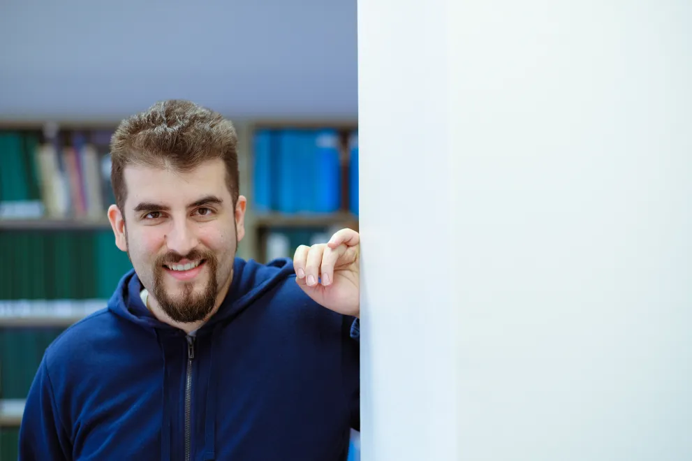 Burak Yilmaz lächelt in die Kamera und lehnt mit dem linken Arm an einer Wand 