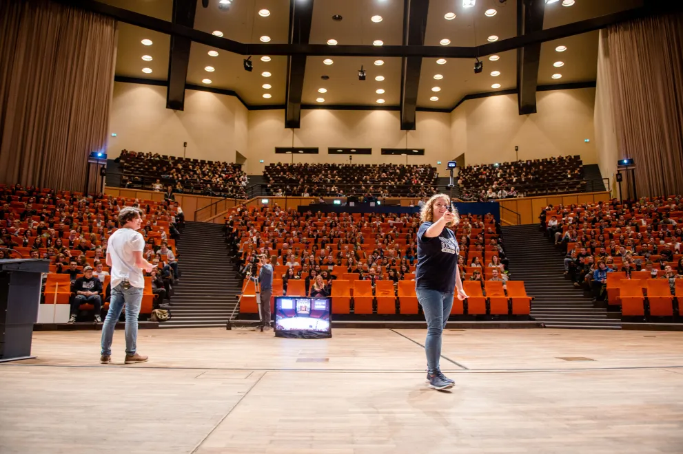 Foto: Veranstaltung im großen Saal des Audimax, fast alle Sitzlätze sind besetzt.