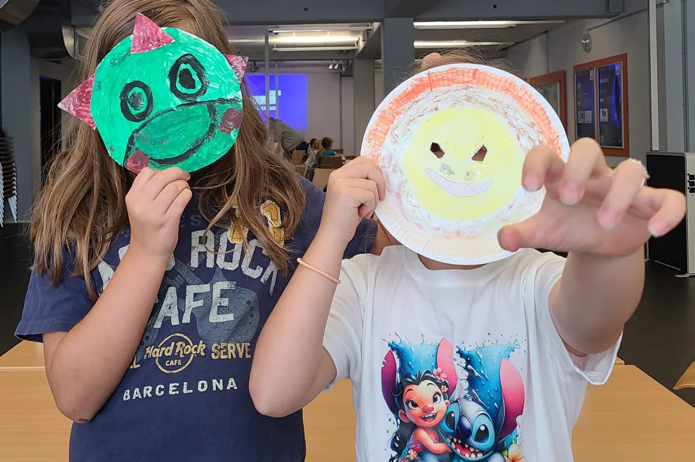 Zwei Kinder mit selbstgemachten Dinosaurier-Masken.