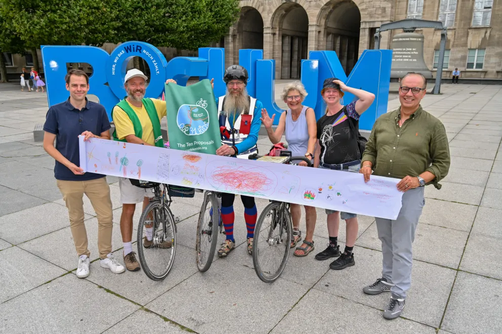 Gruppe Menschen mit Fahrrädern und Bildrolle