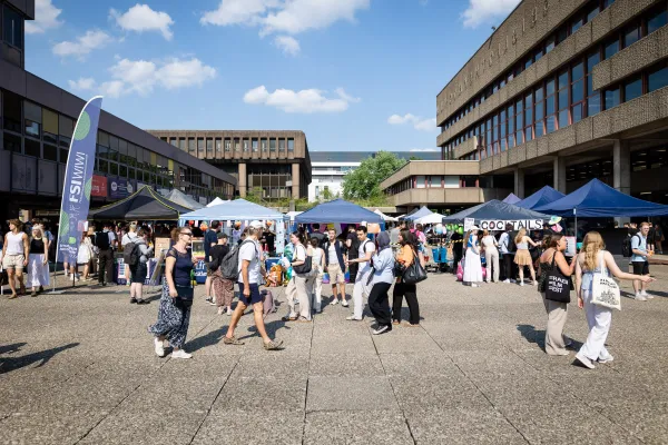 Photo: Stands and visitors in sunny weather at the Nordforum of Ruhr University Bochum