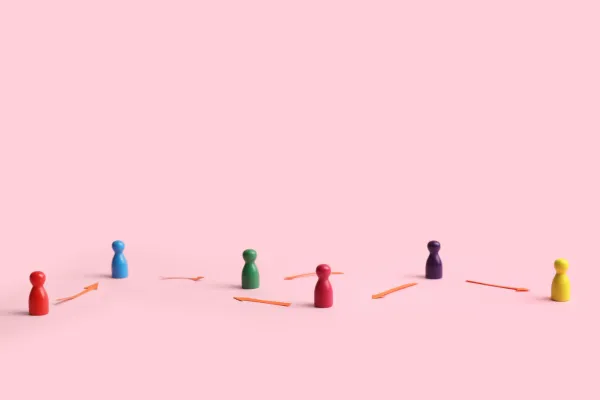 Spielfiguren mit Pfeilen verbunden auf rosa Hintergrund